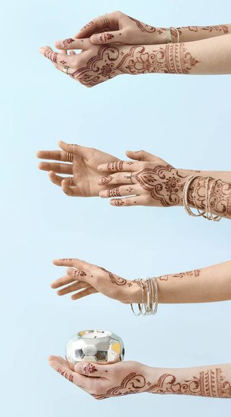Beautiful female hands with henna tattoo on color background - Photo, Image