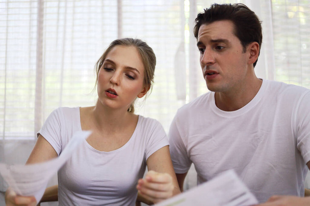 Несчастная молодая пара беспокоится о стоимости счетов по кредитной карте дома. - Фото, изображение