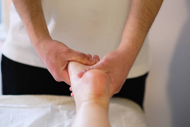 Relaxing massage on the foot in spa salon indoors. - Photo, Image