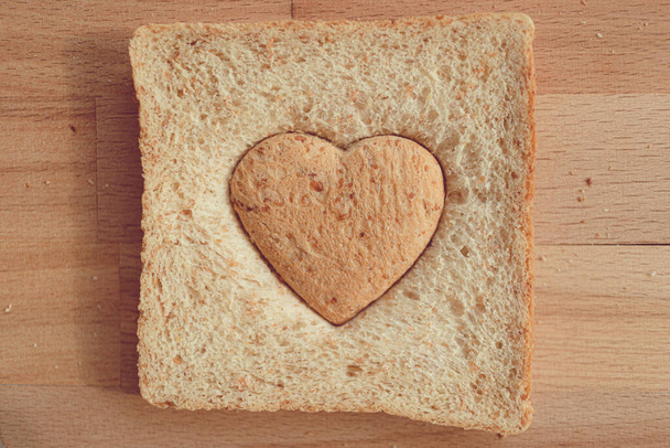 Bread cut off as heart shape. Concept of love and care in Valentine day. - Фото, зображення