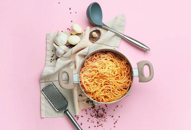Vaření hrnec s těstoviny, nádobí a ingredience na barevném pozadí - Fotografie, Obrázek