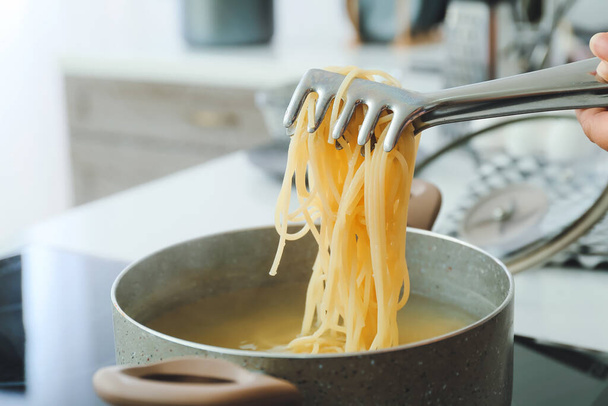 Kochtopf mit Pasta auf Elektroherd in der Küche - Foto, Bild