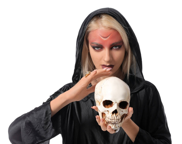 Bruja joven asustadiza con cráneo humano sobre fondo blanco - Foto, imagen