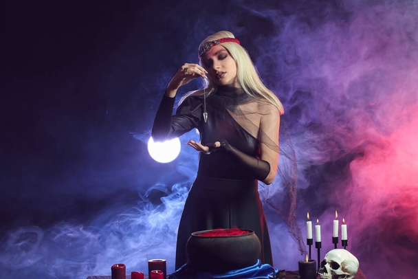 Fiatal boszorkány elvégzése rituálé sötét háttér - Fotó, kép