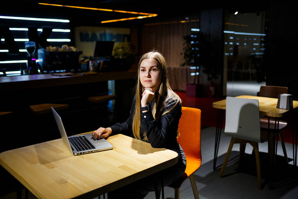Young woman businessman sitting at a table working with a laptop. Girl manager in the office working on a new project - Foto, immagini