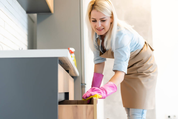 Giovane donna che fa i lavori domestici, la pulizia della cucina - Foto, immagini