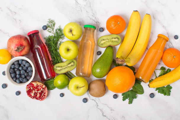 Green, orange and purple fresh juices or smoothies with fruits, herbs, top view, selective focus. Detox, diet, clean food, vegetarian, vegan, fitness, healthy lifestyle concept - Photo, Image