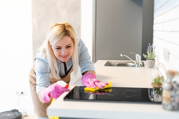 Симпатичная домохозяйка чистит кухню - Фото, изображение