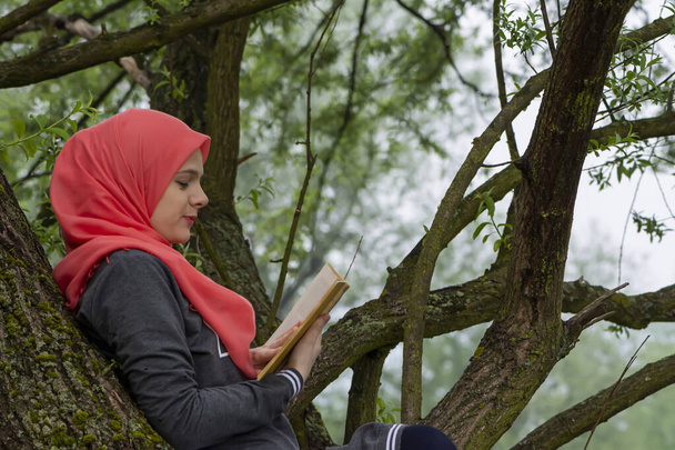 Muslim female student reading a book in nature, outdoor - Photo, Image