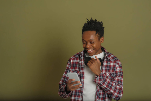 mladý africký Američan chlap mluví po telefonu na zeleném pozadí - Fotografie, Obrázek