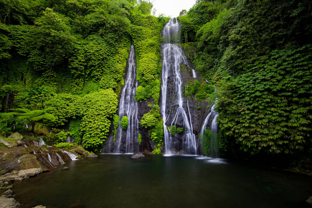 水泳のための巨大な池と滝。熱帯の風景。自然を背景に。旅行の冒険の概念。環境概念。遅いシャッター速度、動きの写真。バヌマラの滝,バリ島インドネシア - 写真・画像