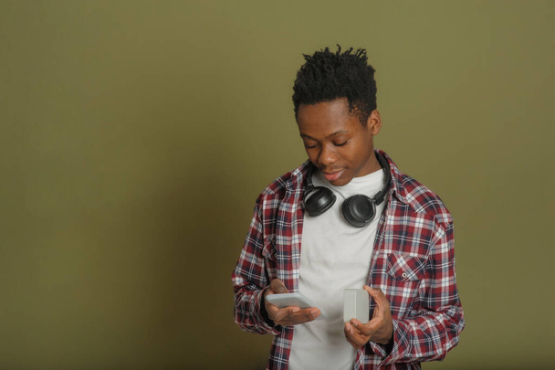 young black guy connects bluetooth speaker to phone - Fotoğraf, Görsel
