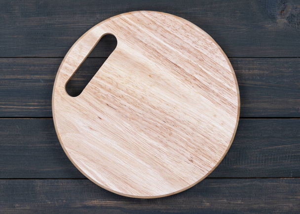 Wooden round empty cutting board on a wooden table close up - Photo, Image