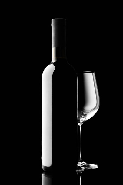 red wine bottle and wine glass isolated on black background - Фото, изображение
