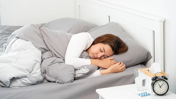 Beteg ázsiai nő hideg alszik az ágyon otthon magas láz szenved álmatlanság  - Fotó, kép