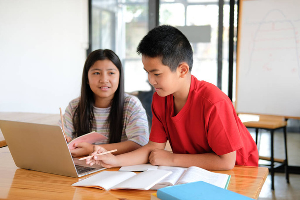 азиатский мальчик девочка студент изучает урок онлайн. дистанционное обучение на дому - Фото, изображение