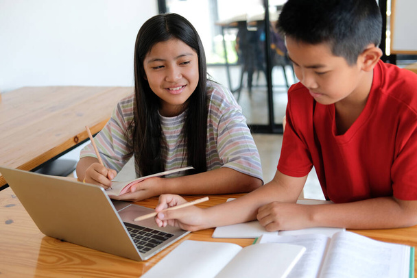 азиатский мальчик девочка студент изучает урок онлайн. дистанционное обучение на дому - Фото, изображение
