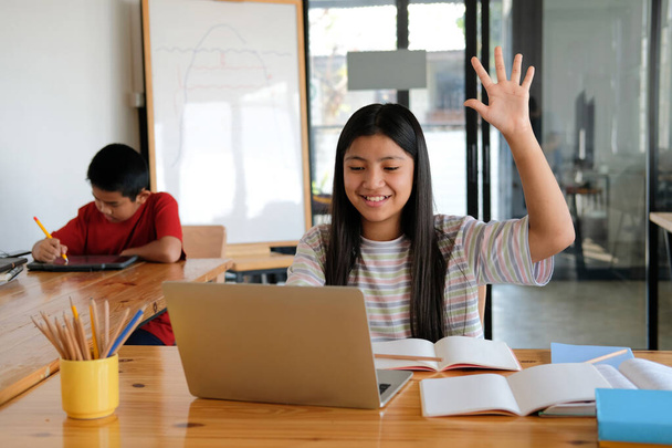 азіатська дівчина студентка піднімає руку, вивчаючи урок навчання онлайн. дистанційна дистанційна освіта вдома
 - Фото, зображення