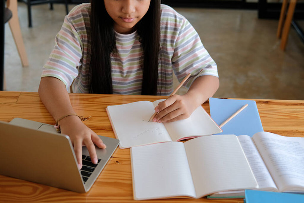 アジアの女子学生がオンラインで授業を勉強しています。家庭での遠隔会議遠隔教育 - 写真・画像