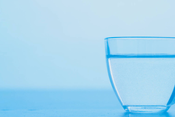 A cup of clear blue water. The concept of World Water Day. - 写真・画像