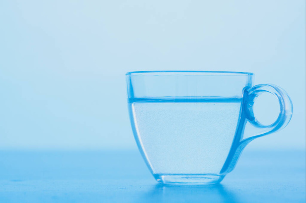 A cup of clear blue water. The concept of World Water Day. - Fotoğraf, Görsel