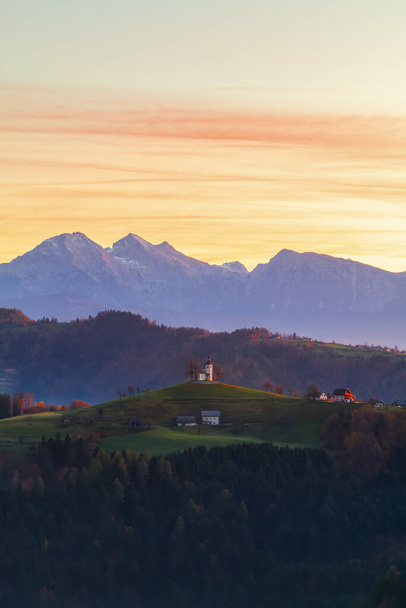 Eglise Sveti Tomaz (Saint Thomas) au sommet d'une colline au beau lever du soleil en automne, près de Skofja Loka dans la région de Haute Carniole en Slovénie - Photo, image