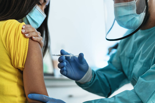 コロナウイルス発生の予防と停止のための女性患者へのワクチン注射を行う医療従事者-健康医学とコビドに対する治療19疾患の概念 - 写真・画像