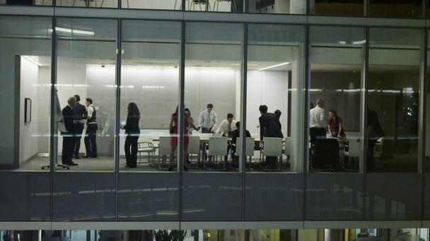Diversi team di lavoro in sala riunioni a tarda notte nell'ufficio contemporaneo
 - Filmati, video