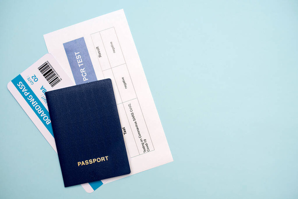 Документи для авіаперевезень під час епідемії COVID-19: паспорт, квиток, тест на ПЛР COVID-19 на синьому фоні, крупним планом
. - Фото, зображення