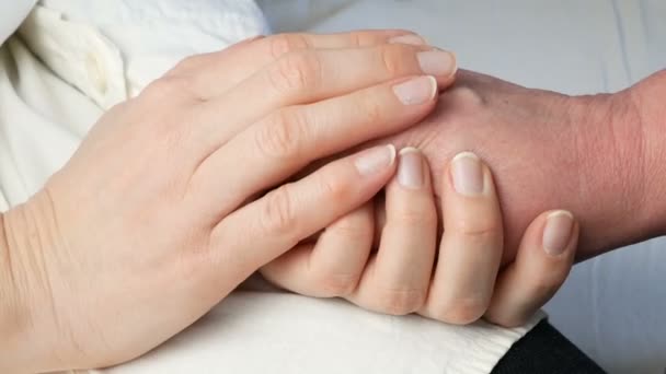 Mãos de médico segurando as mãos do paciente como expressão de cuidado e apoio, close-up - Filmagem, Vídeo