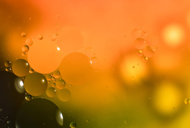 Abstract background with colorful oil drops in water. Psychedelic pattern image. Spheres on blurred yellow and green colored background. Oil drops and shaddows in a water. - Zdjęcie, obraz