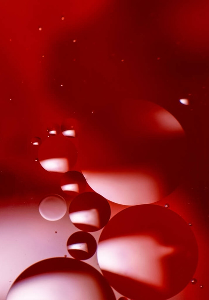 Abstract background with colorful oil drops in water. Psychedelic pattern image. Spheres on blurred red, purple and scarlet colored background. Oil drops and shaddows in a water. - Фото, изображение