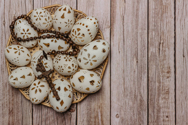 Happy Easter.White χειροποίητα πασχαλινά αυγά με σταυρό σε ξύλινο καλάθι.Πλαίσιο διακόσμησης. Εορταστική παράδοση για τις χώρες της Ανατολικής Ευρώπης. - Φωτογραφία, εικόνα