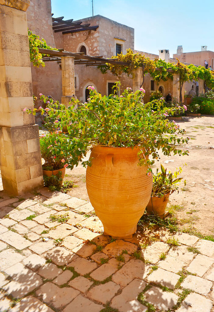 The beautul clay amphora with flowers in garden of Arkadi Monastery (Moni Arkadiou), Crete, Greece - Foto, Bild