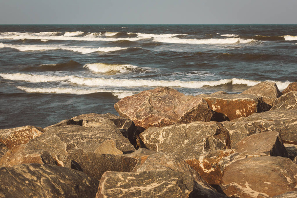 Scenic view of rocks with the Bay of Bengal in the background along Kovalam Beach, Chennai, India - Photo, Image