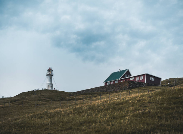 View Towards Lighthouse on the island of Mykines Holmur, Faroe Islandson a cloudy day with view towards Atlantic Ocean. - Φωτογραφία, εικόνα