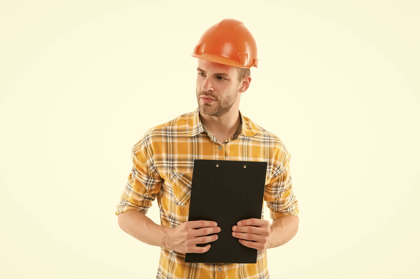 Counting finances for renovation. Man wear safety hard hat. Redevelopment of home. Renovation concept. Planning changes renovation apartment. Foreman with documents. Supplies dealer. Project curator - Fotó, kép
