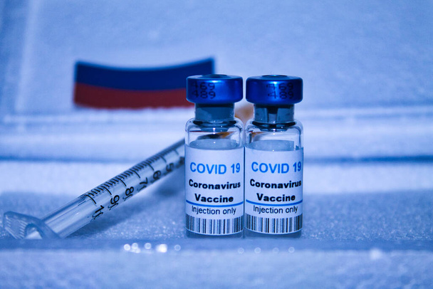dos dosis de vacuna y jeringa covid 19 envasadas en una caja protectora de polispan - Foto, imagen