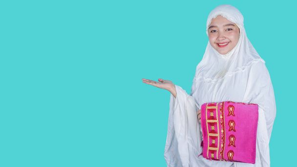 Ied Mubarak Concept - mulher asiática vestindo hijab cachecol mukena enquanto apresenta - espaço livre cópia - Foto, Imagem