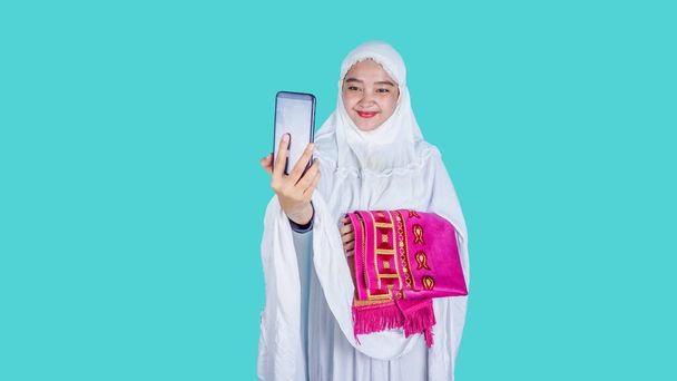 Азійська мусульманка телефонує з сім'єю на мобільний телефон. Ied Mubarak, Ramadan New Normal Concept - Фото, зображення