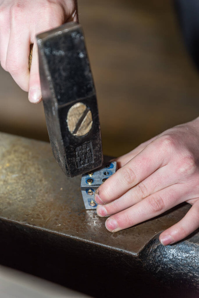 Métallurgiste travaille avec le marteau et le métal sur enclume - gros plan - Photo, image