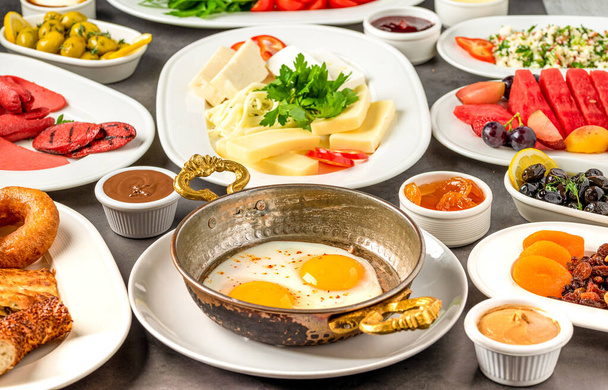 Традиционный турецкий завтрак с традиционным турецким чаем на каменном столе - Фото, изображение