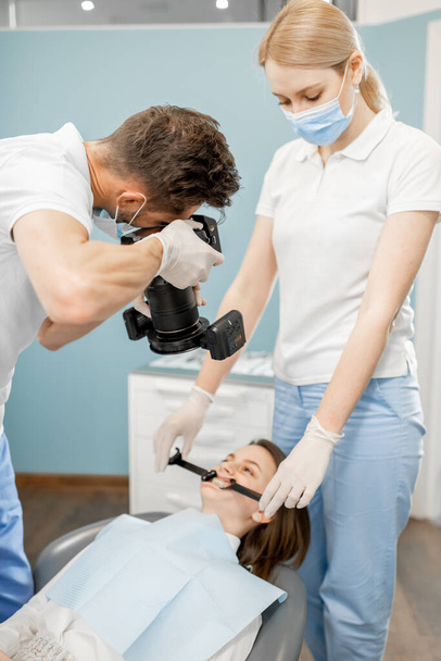 Dentysta fotografujący wyniki swojej pracy - Zdjęcie, obraz