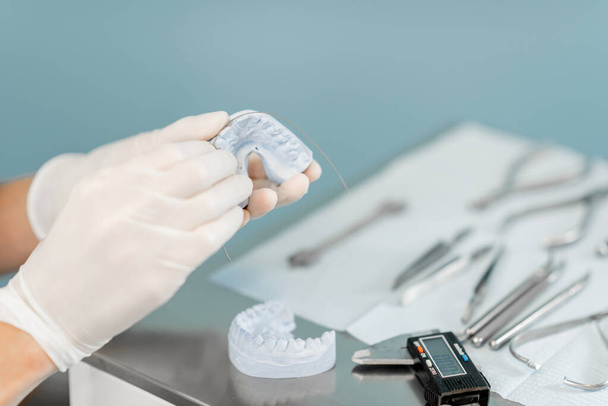 Dental technician working with a model of teeth and dental braces - Φωτογραφία, εικόνα