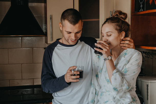 Valentines Day at home. Romantic relationship quality time. Couple slow day spent indoors, drinking coffee and hugging in kitchen - Fotografie, Obrázek