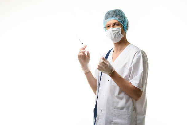 Cirujano sostiene una jeringa en sus manos y miró dentro del marco, aislado sobre fondo blanco - Foto, Imagen