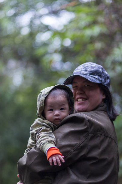 Mãe de família feliz e bebê abraçando na floresta tropical Natureza. Feliz família harmoniosa ao ar livre. - Foto, Imagem