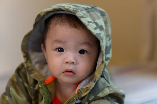 Aranyos ázsiai kisfiú álcázó kabát - Fotó, kép