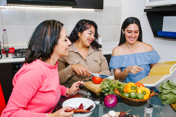 Drie Spaanse vrouwen die samen groenten koken in een Mexicaanse keuken in Latijns-Amerika - Foto, afbeelding