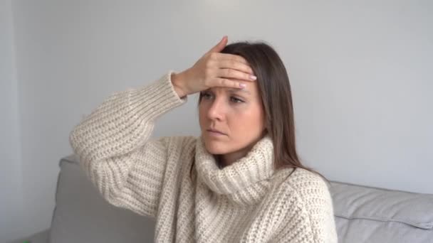 Mulher jovem doente triste com febre medir a temperatura com termômetro médico em casa - Filmagem, Vídeo